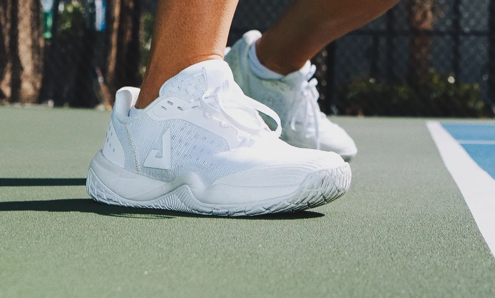Đôi giày pickleball JOOLA R4LLy màu trắng trên mặt sân ngoài trời